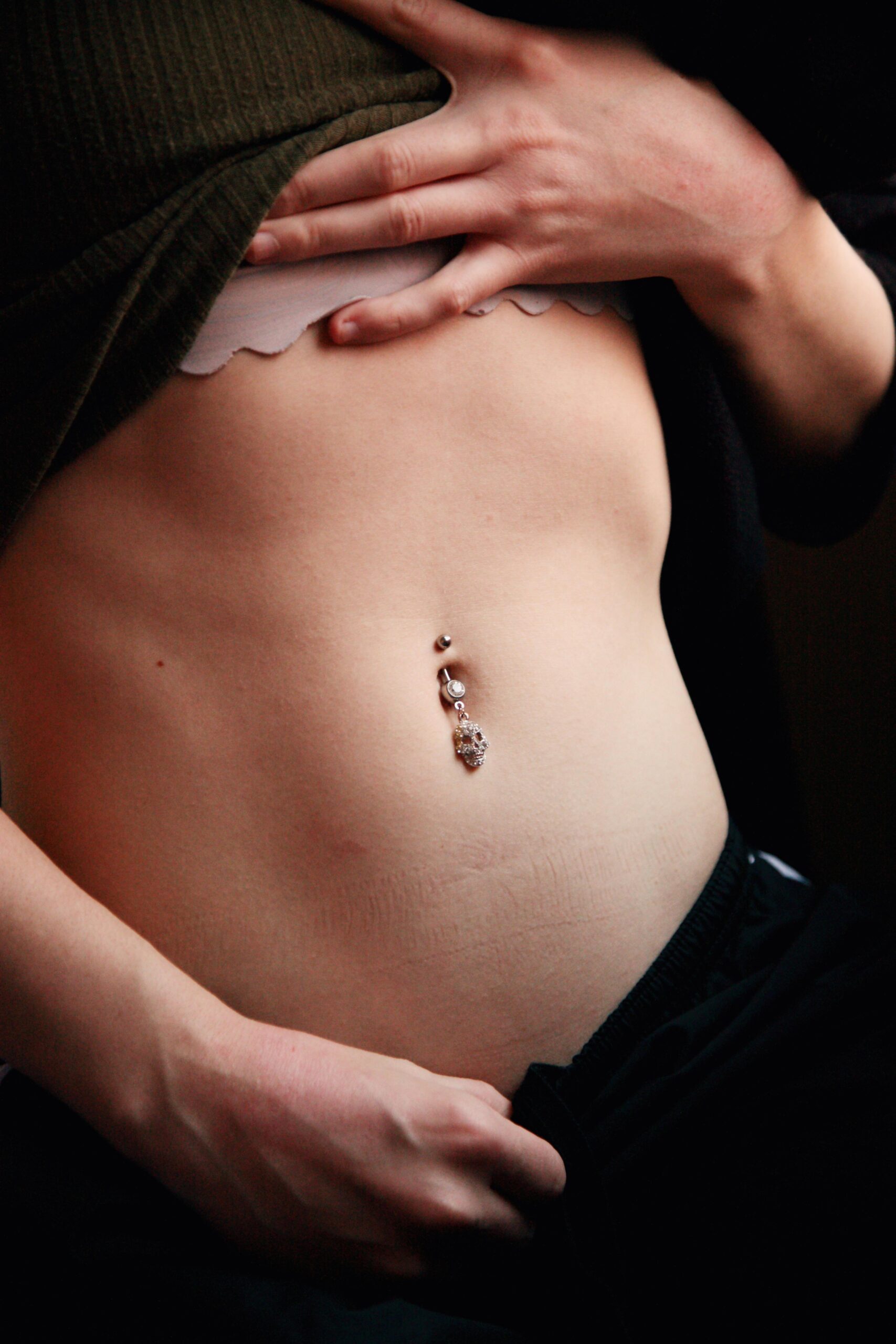 Close-up image showcasing a pierced belly button adorned with jewelry on smooth skin.
